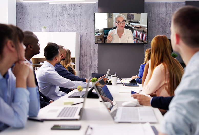 people in a conference room meeting via video with Eli Mansfield